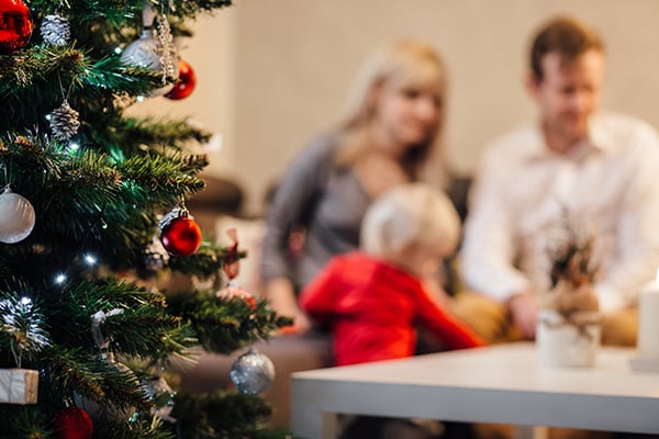 Christmas decorations on a table with a wine glass and candles