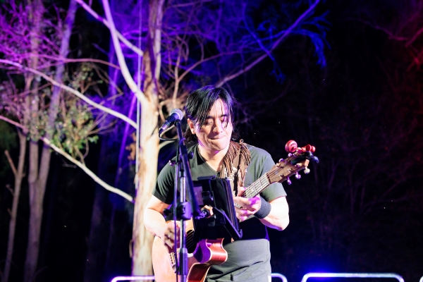 An artist playing guitar at Real Festival