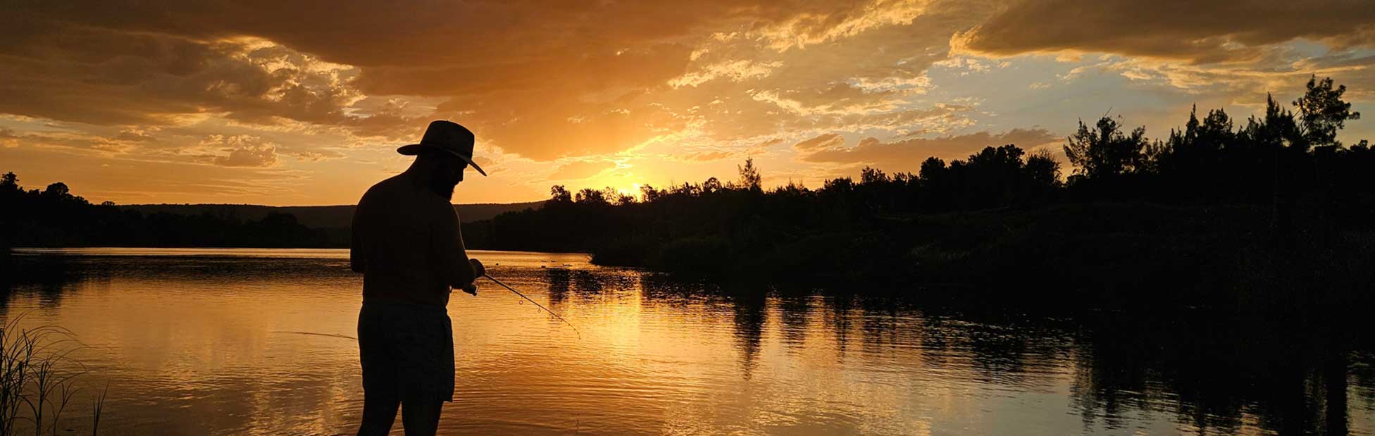 man fishing on river sunset backdrop
