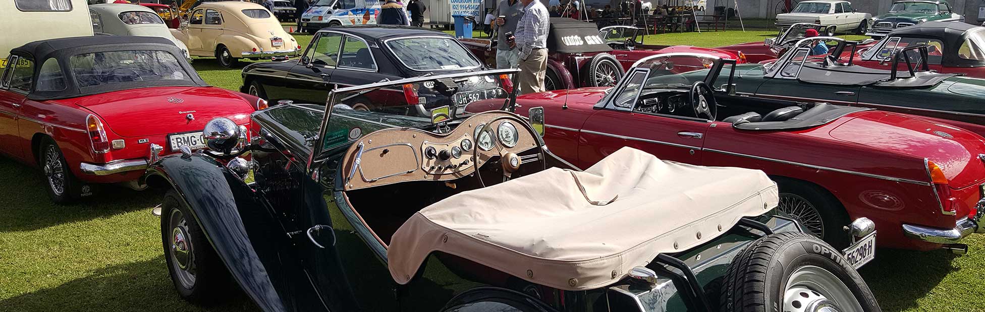 Vintage green convertible automobile surrounded by other display cars
