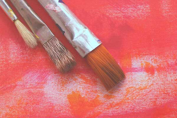 Paint brushes on pink background
