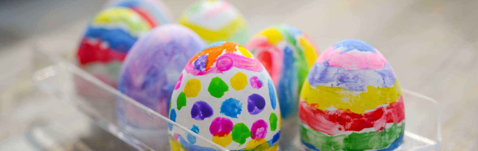 Easter eggs painted with bright colours in holder