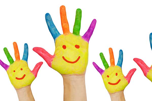 Painted hands with smiley faces waving