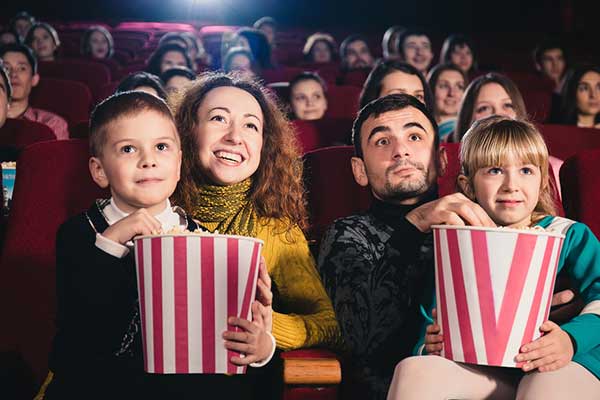 Family watching movie eating popcorn