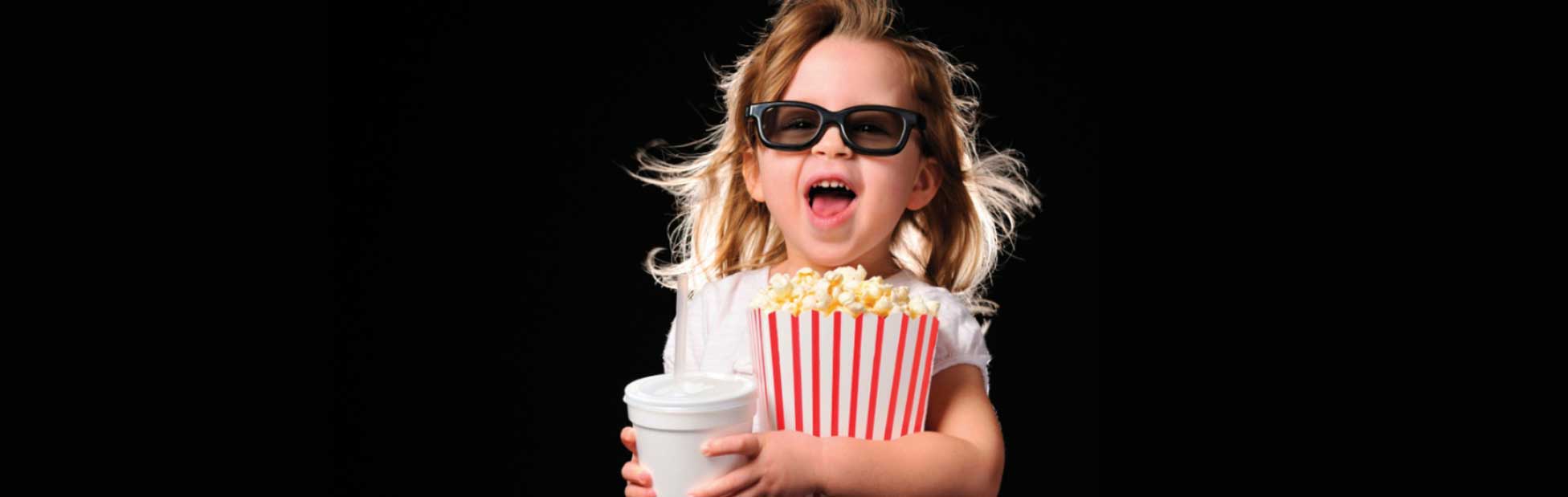 Girl with glasses on holding large popcorn