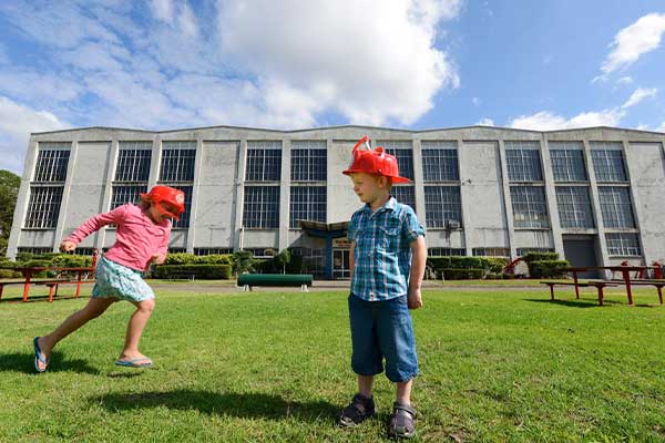Children in fire hats outside Museum