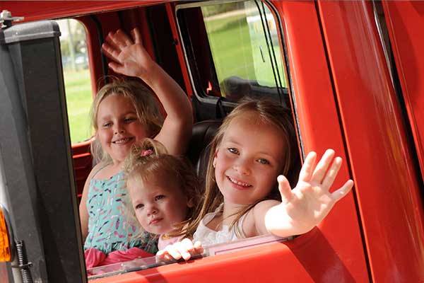 three girls waving from Fire truck