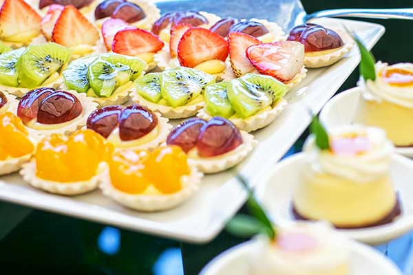 Variety of fruit topped treats on square plate
