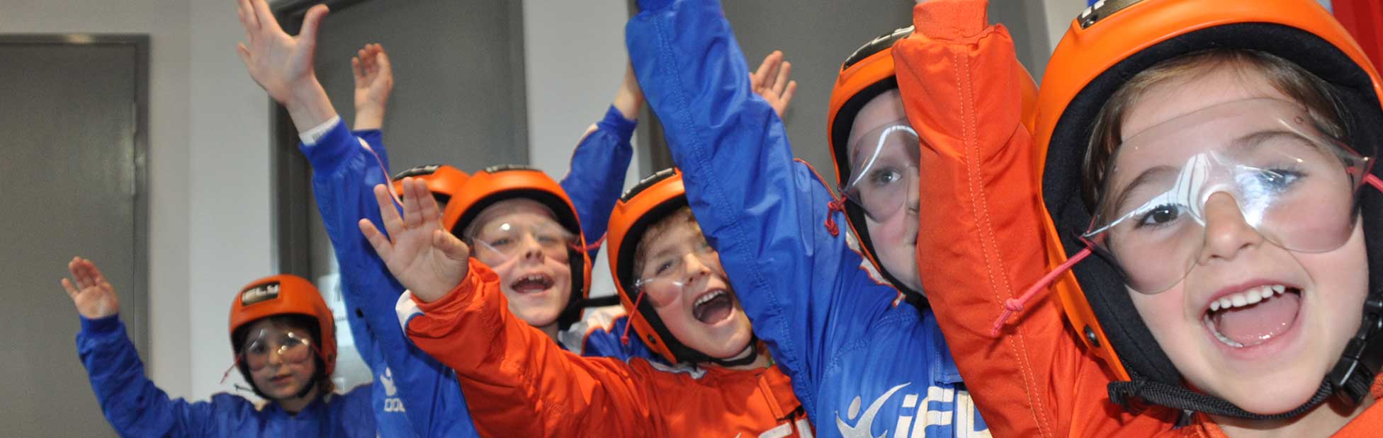 Children dressed to iFLY cheering with hands up