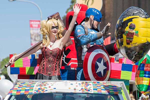 Superheros waving from vehicle in parade