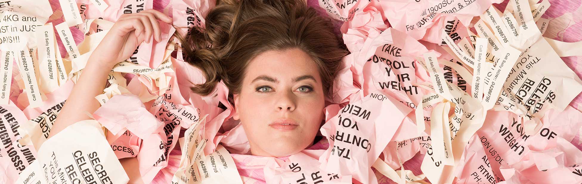 Woman lying among pink notes