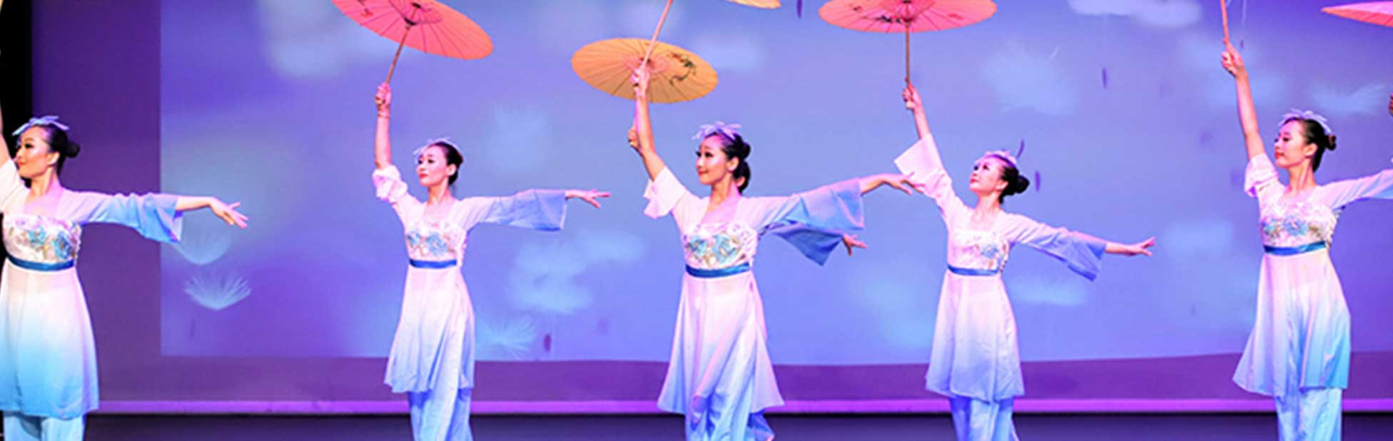 Chinese dancers in traditional costume holding umbrellas