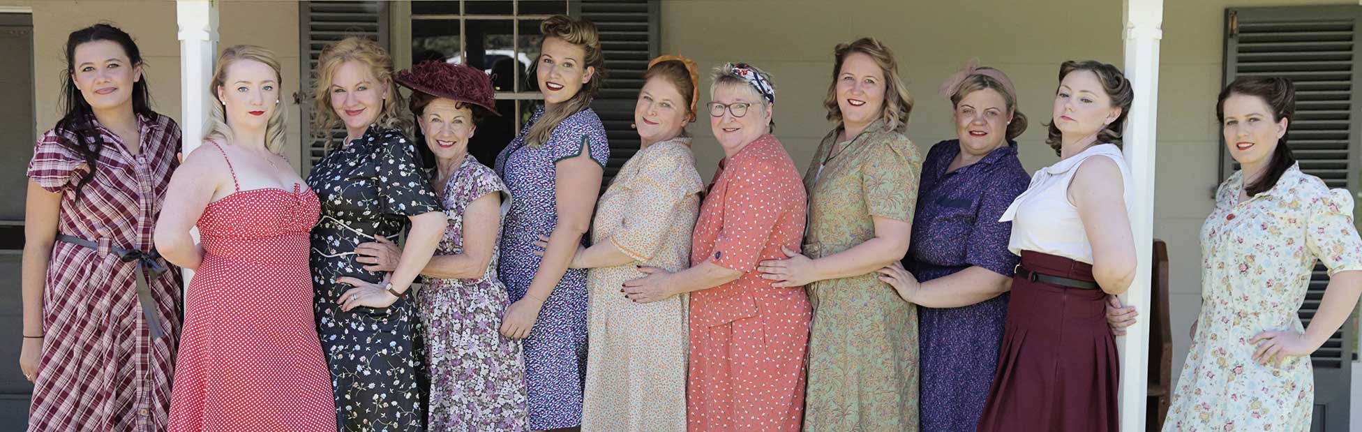 Women in a line all wearing 40's style dresses
