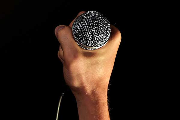 Hand holding microphone in tight fist grip