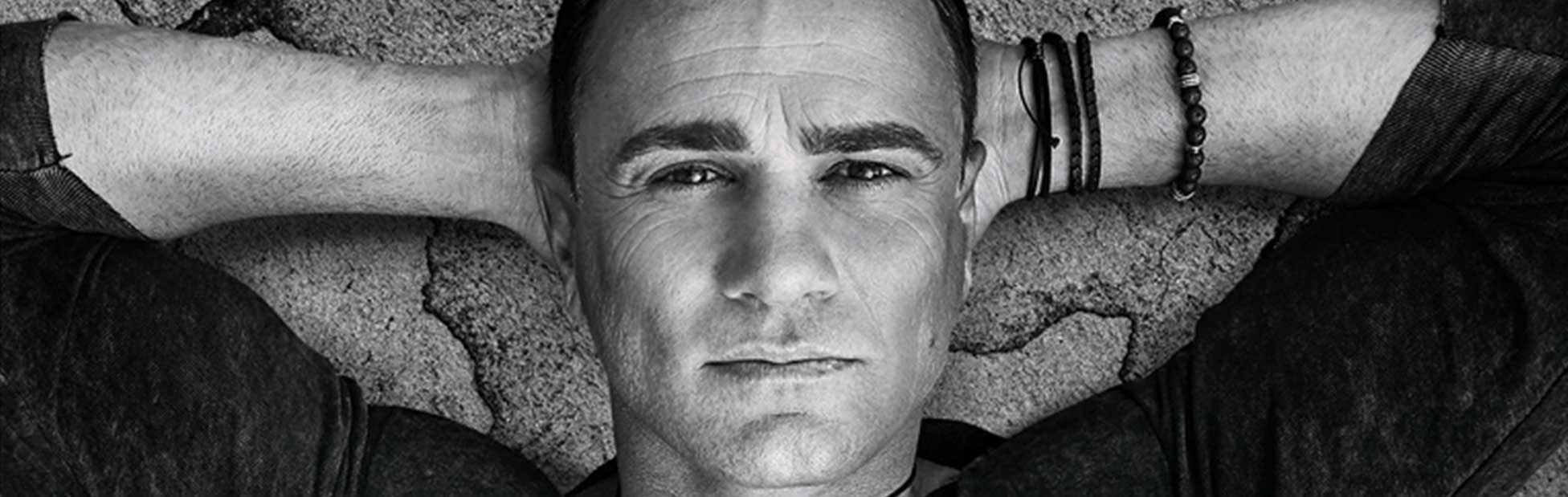 Shannon Noll lying on his back hands on head looking up