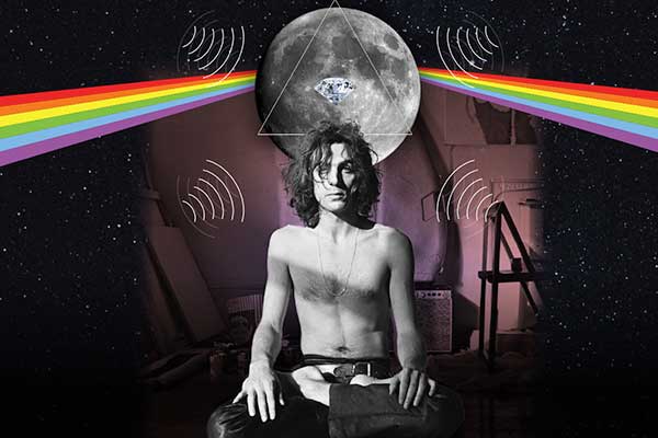 man sitting with legs crossed under rainbow