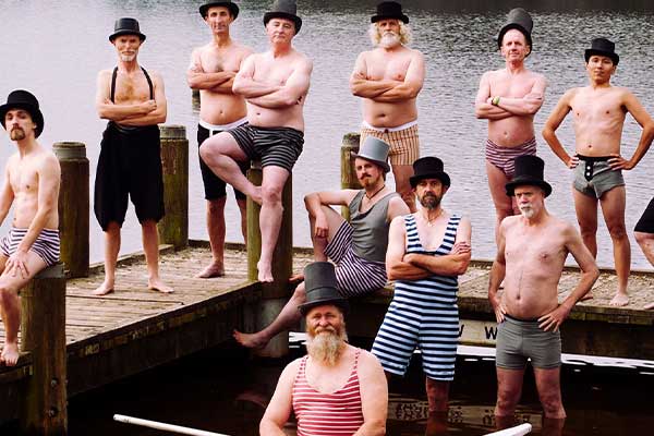 Men posing for picture in old style bathing costumes