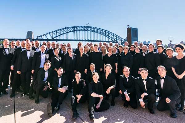 Choir posing for photo in front of Sydney Harbour Bridge