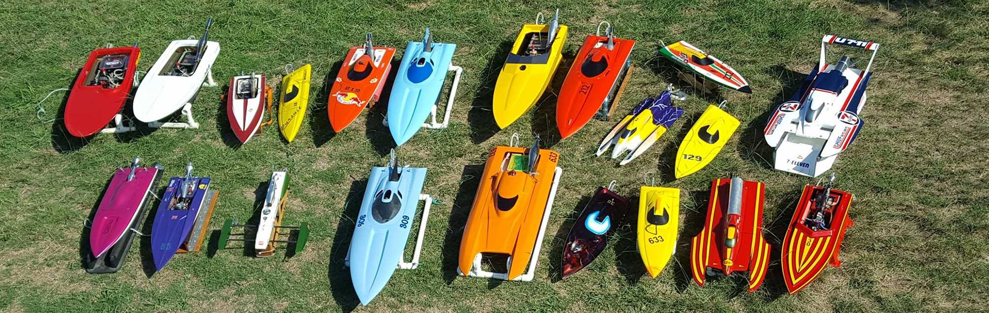 Colourful model boats in rows on green grass