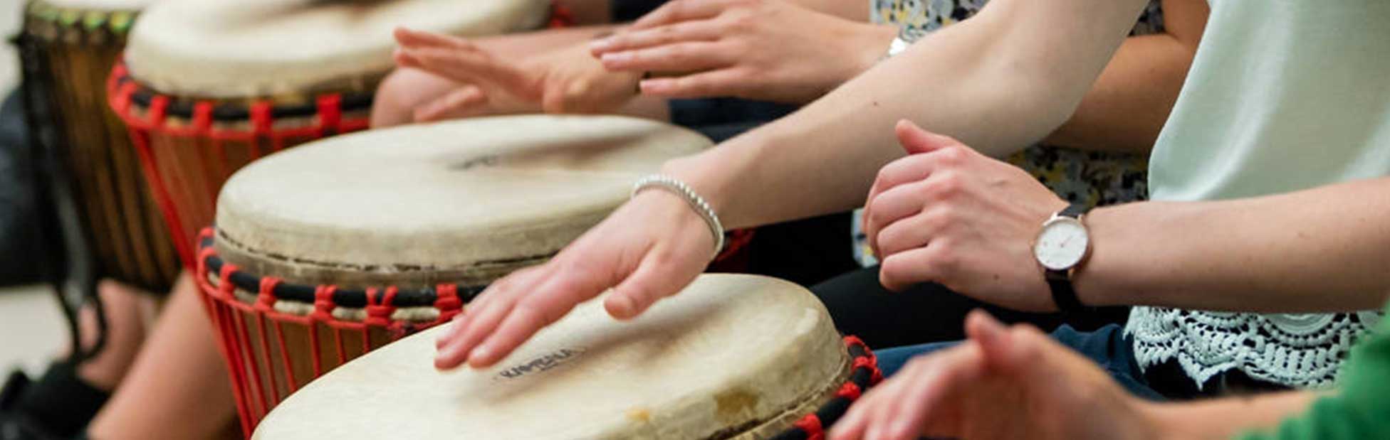 Hands playing large drums