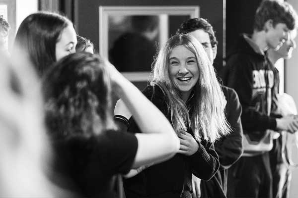 Girl laughing at having picture taken by two other girls