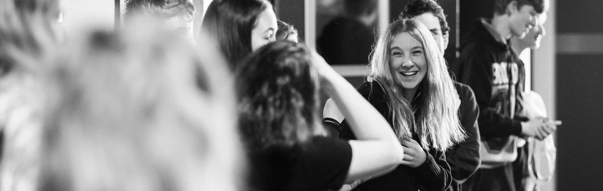 Girl laughing at having picture taken by two other girls