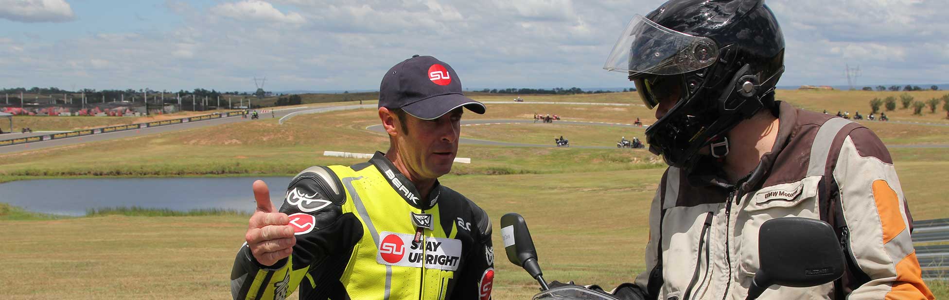 Instructor talking to motorcyclist on side of track