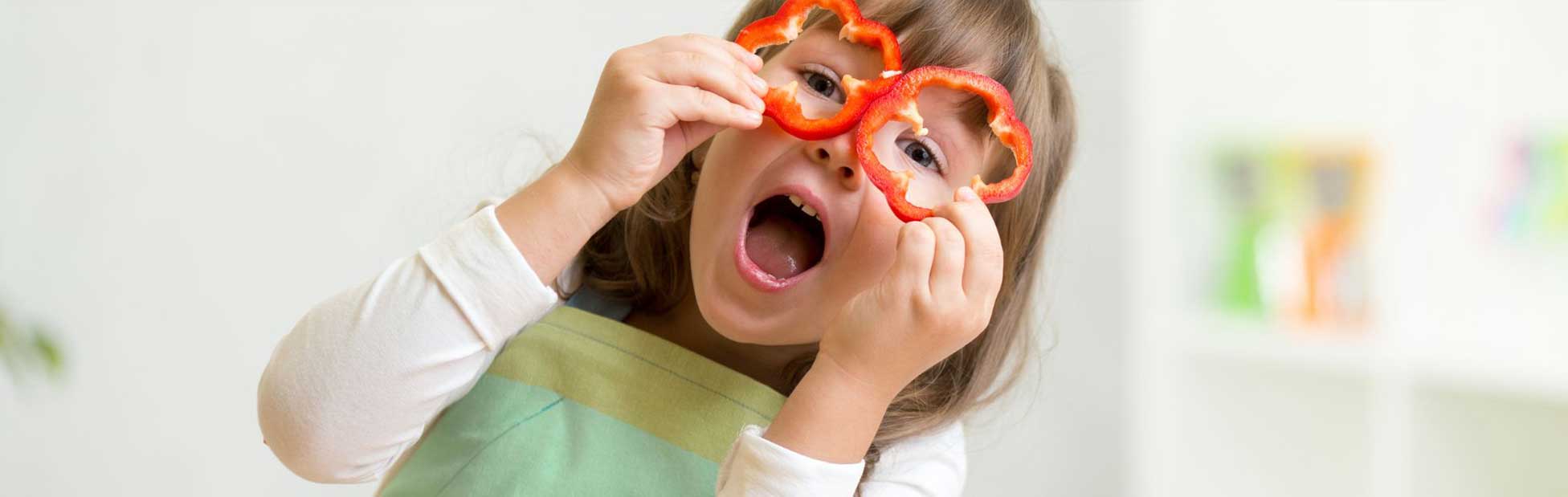 girl holding capsicum to her eyes like glasses