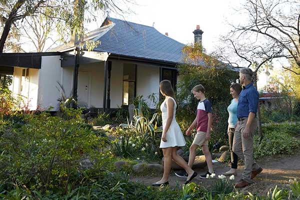 Family walking through garden and past historic gallery building