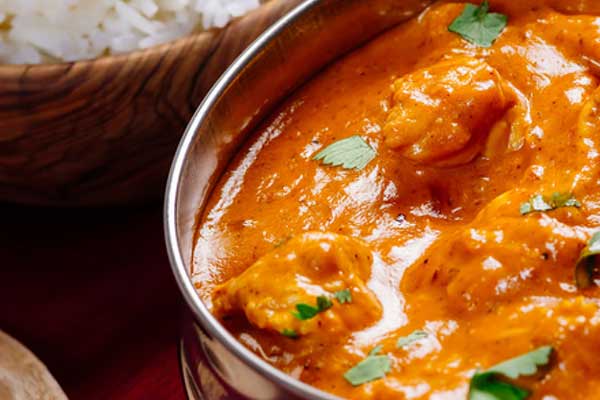 Butter chicken curry cooking in a large pot