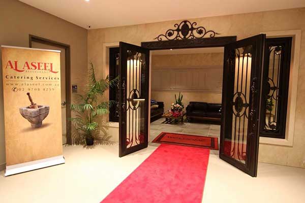 A grand entrance with ornate timber door and tiled flooring leading into Al Assel