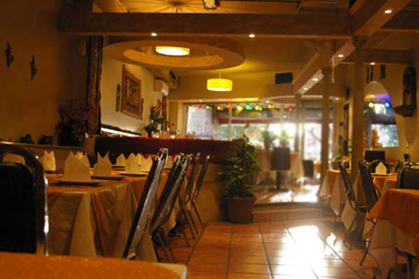 The interior of the Bai Bua Restaurant, with an arrangement of tables and chairs and folded napkins and cutlery on the tables