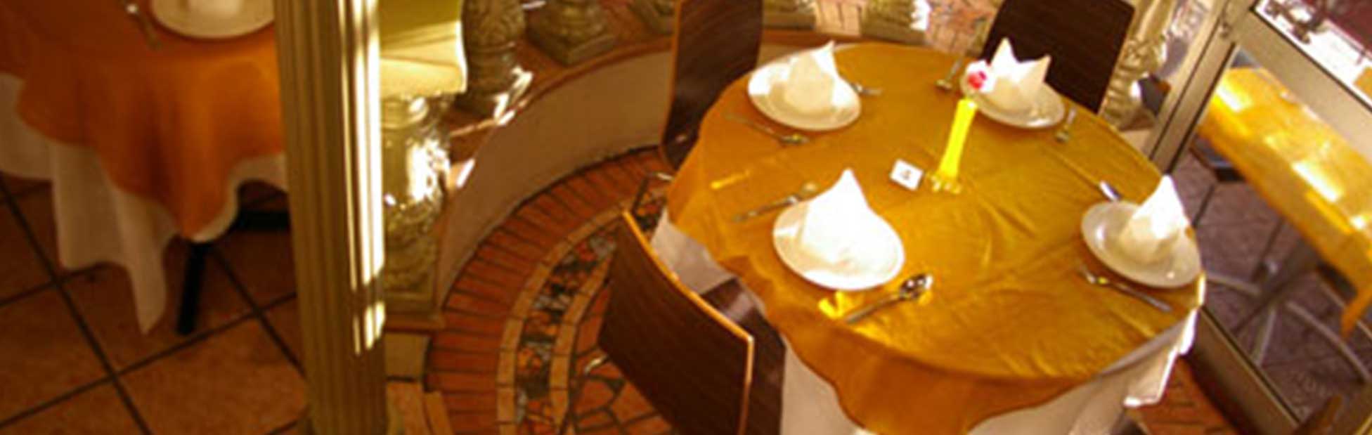 The interior of the Bai Bua Restaurant, with an arrangement of tables and chairs and folded napkins and cutlery on the tables