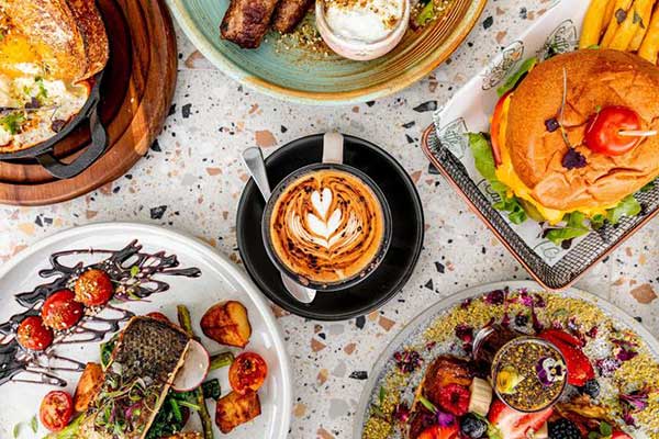 Coffee surrounded by plates of food