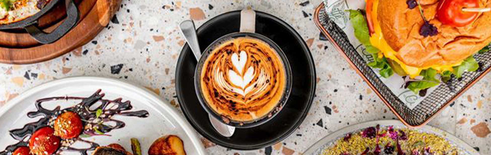 Coffee surrounded by plates of food