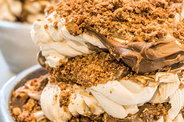 A serving of gelato with chocolate and crushed nuts