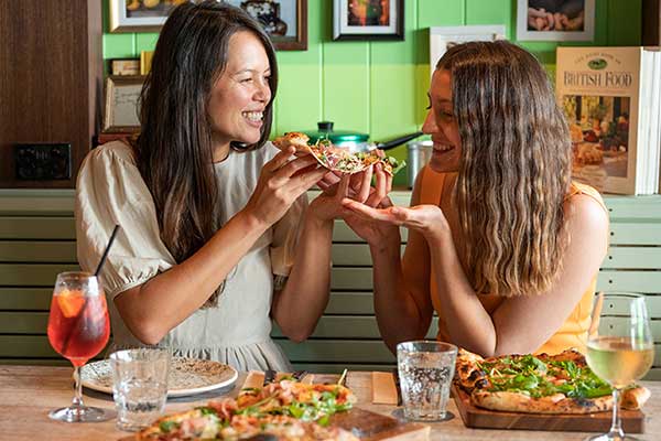Two ladies eating pizza