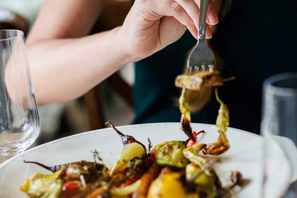 woman eating meal with fork