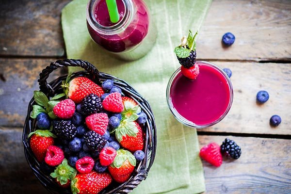 Fresh berries in a basket with a cup of juice