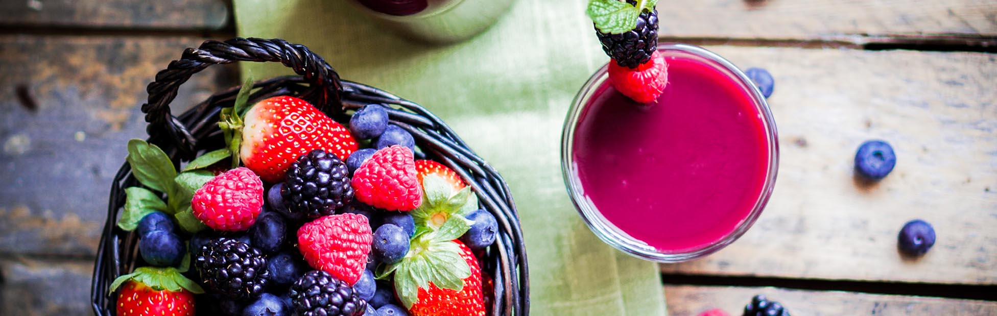 Fresh berries in a basket with a cup of juice