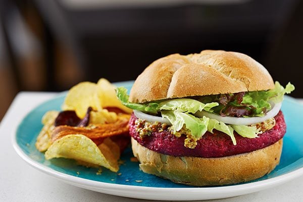 A gourmet burger with chips on a plate