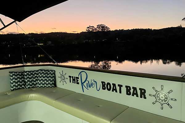 sign on backseat of boat with sunset