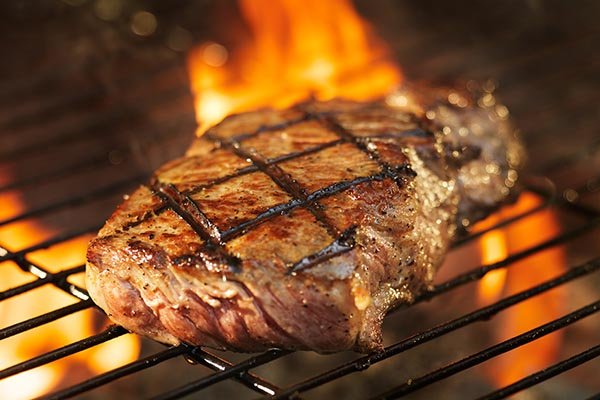 A steak on a flaming grill