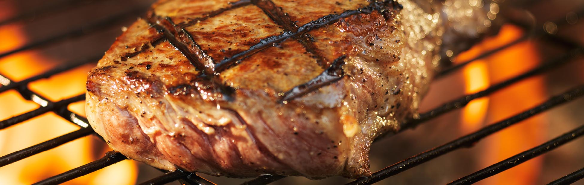 A steak on a flaming grill