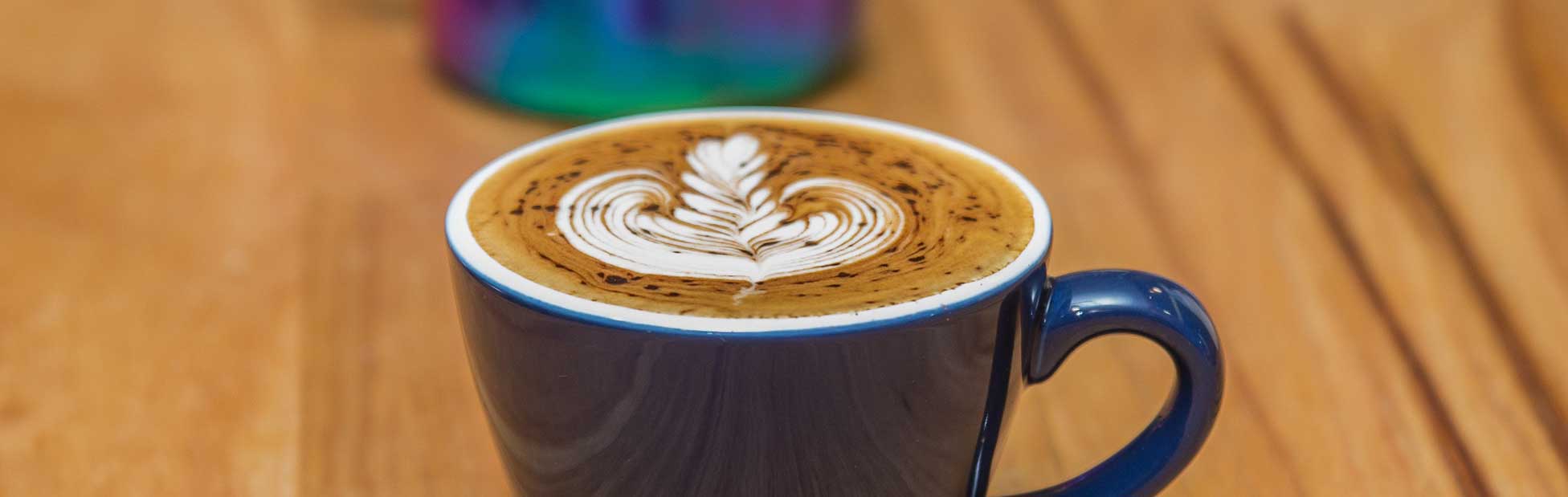 Coffee with spectacular barista art in blue cup