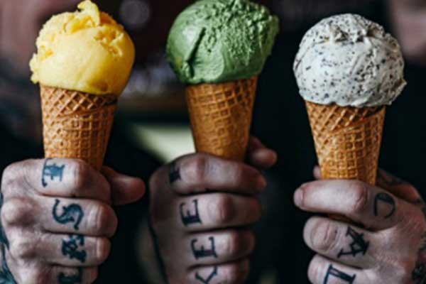 tattooed hands holding cones of gelato