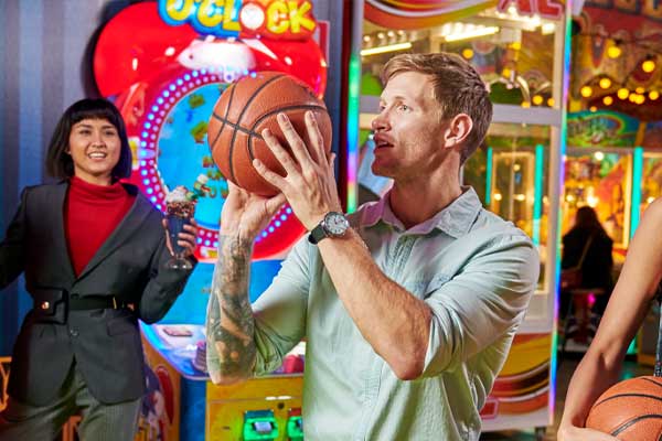 man in arcade shooting basketball