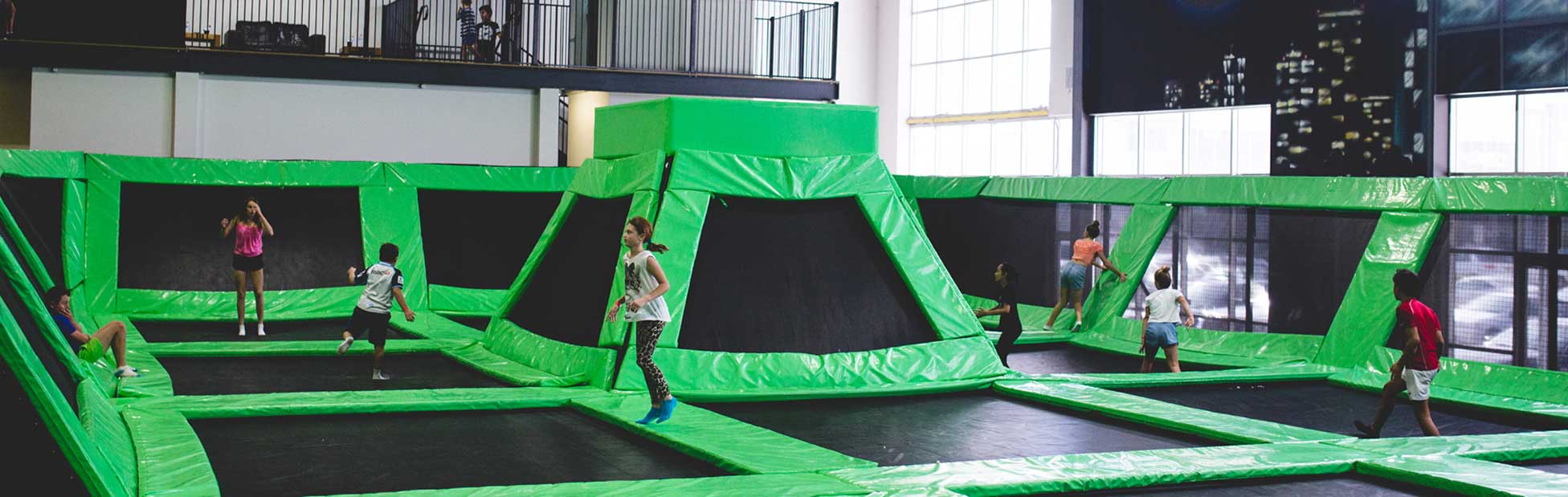 Kids jumping around on trampolines inside an indoor playground