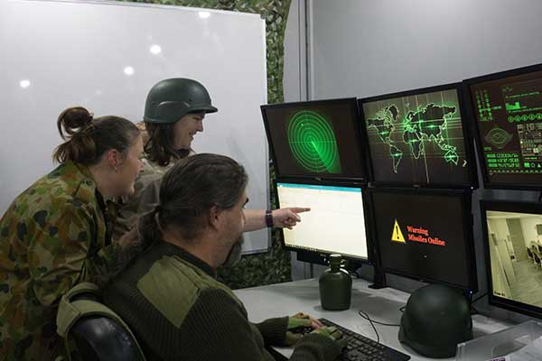 Three people at PC in military costumes