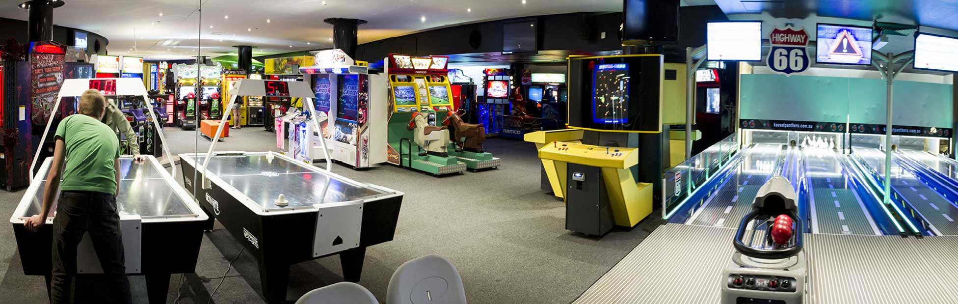 A large room filled with arcade games, pinball machines and air hockey tables